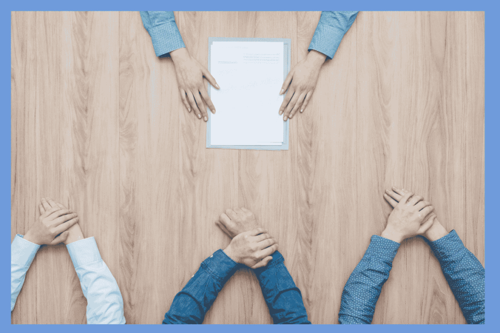 テーブル越しに面接を受けるシーンの上からの構図